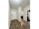 Hallway leading to other rooms, featuring wood floors, neutral paint, and a view of office space at 1056 Naes Ln, Lake Wales, FL 33853