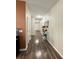 Long hallway with wood flooring, leading to the front door and various rooms at 1056 Naes Ln, Lake Wales, FL 33853
