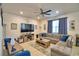 Bright living room with a gray sectional sofa, a large tv, and blue decor elements at 1091 Sugarwood St, Davenport, FL 33837