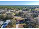 Aerial view of a single-Gathering home surrounded by lush greenery and a long drive way at 11 Sun Air Blvd E, Haines City, FL 33844