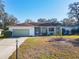 Charming single-story home featuring an attached garage, well-maintained lawn, and welcoming front porch at 11 Sun Air Blvd E, Haines City, FL 33844