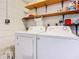Bright laundry area featuring a white washer and dryer, with wooden shelving for storage at 11 Sun Air Blvd E, Haines City, FL 33844