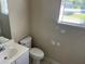 This bathroom features a sink vanity and toilet with a window providing natural light at 1106 Partridge Way, Kissimmee, FL 34759