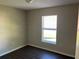 Comfortable bedroom with modern wood-look floors, neutral walls, and a window providing natural light at 1106 Partridge Way, Kissimmee, FL 34759
