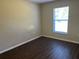 Bright bedroom with wood-look floors, a window offering natural light, and neutral paint for a relaxing ambiance at 1106 Partridge Way, Kissimmee, FL 34759