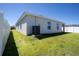 Backyard featuring well-maintained lawn and a modern home exterior, enclosed with a white fence at 1108 Zion Dr, Haines City, FL 33844