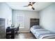 Neutral bedroom featuring wood-look floors, single bed, ceiling fan, desk, and natural light at 1108 Zion Dr, Haines City, FL 33844