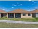 Home exterior showcasing a screened lanai, offering a relaxing outdoor space with views of the lawn at 1124 Sawgrass Dr, Winter Haven, FL 33884