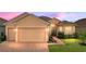 Charming single-Gathering home featuring a manicured lawn, brick driveway, and attached two-car garage at 1124 Sawgrass Dr, Winter Haven, FL 33884