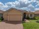 Charming single-Gathering home featuring a manicured lawn, brick driveway, and attached two-car garage at 1124 Sawgrass Dr, Winter Haven, FL 33884