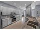 Well-lit kitchen with grey cabinetry, granite countertops, and stainless steel appliances at 1124 Sawgrass Dr, Winter Haven, FL 33884