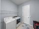 Well-lit laundry room with modern washer and dryer and shelving for storage at 1124 Sawgrass Dr, Winter Haven, FL 33884