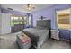 Inviting main bedroom featuring soft lilac walls, a cozy bed, and bright windows at 1124 Sawgrass Dr, Winter Haven, FL 33884