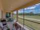 Inviting screened patio with views of a lush green landscape, perfect for outdoor dining and relaxation at 1124 Sawgrass Dr, Winter Haven, FL 33884