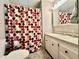 Bathroom features a shower with a curtain, a white vanity, and a mirrored medicine cabinet at 114 Jana Cir, Auburndale, FL 33823