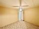 A bedroom showcases a ceiling fan, neutral walls, carpeted floors, and access to a hallway at 114 Jana Cir, Auburndale, FL 33823