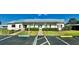 The community clubhouse features a metal roof, mature landscaping, and designated parking at 114 Jana Cir, Auburndale, FL 33823
