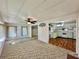 Bright living room open to kitchen with ceiling fan and natural light from large windows at 114 Jana Cir, Auburndale, FL 33823