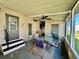 This cozy covered porch offers an outdoor seating area with a ceiling fan for added comfort at 114 Jana Cir, Auburndale, FL 33823