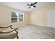 Bright bedroom featuring sleek ceiling fan, modern gray floors, and dual windows at 1302 Windsong Dr, Lakeland, FL 33811