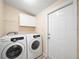 Convenient laundry room with modern washer and dryer and ample cabinet space at 1302 Windsong Dr, Lakeland, FL 33811