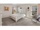 Bright bedroom with white bedding, soft chair, natural lighting, and neutral carpet at 135 Krenson Bay Loop, Winter Haven, FL 33881