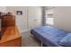 Simple bedroom with blue bedding, dresser, and soft carpeting at 135 Krenson Bay Loop, Winter Haven, FL 33881