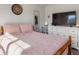 Comfortable bedroom with pink bedding, natural light, and modern decor at 135 Krenson Bay Loop, Winter Haven, FL 33881