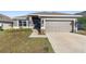 Charming single-story home featuring a well-maintained lawn and a two-car garage at 135 Krenson Bay Loop, Winter Haven, FL 33881