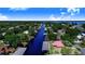 Aerial view of canal-front home with a red roof, lush trees, and easy water access at 142 Lakeview Dr, Haines City, FL 33844