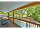 Covered back porch overlooking a swimming pool, lush greenery and tall trees at 151 Lake Ring Dr, Winter Haven, FL 33884