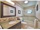 Well-lit bathroom featuring granite countertops, a stylish mirror, and a bathtub with glass doors at 151 Lake Ring Dr, Winter Haven, FL 33884