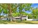 Charming two-story home with mature trees, white siding, and a well-manicured lawn in a serene setting at 151 Lake Ring Dr, Winter Haven, FL 33884