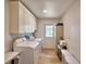 Efficient laundry room featuring a washer, dryer, cabinets, and an exterior door at 151 Lake Ring Dr, Winter Haven, FL 33884