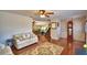 Open-concept living area with hardwood floors, comfortable seating, and views of the adjacent dining area and staircase at 151 Lake Ring Dr, Winter Haven, FL 33884