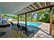Charming outdoor pool area with brick patio and a cozy covered seating space at 151 Lake Ring Dr, Winter Haven, FL 33884
