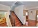 Elegant staircase leading to the upper level, adjacent to a living area with hardwood floors and neutral decor at 151 Lake Ring Dr, Winter Haven, FL 33884