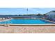 Community pool with a lake view and lounge chairs around the pool area at 1550 11Th Ne St # G6, Winter Haven, FL 33881
