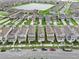 Residential area aerial showcasing homes with well-maintained lawns and a tranquil lake in the background at 1744 Cross Prairie Pkwy, Kissimmee, FL 34744
