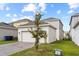Attached garage and paver driveway with green lawn in the background at 1744 Cross Prairie Pkwy, Kissimmee, FL 34744
