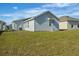 View of the home's backyard, showing the exterior, landscaping, and fresh green grass at 1998 Sarah St, Winter Haven, FL 33884