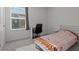 A sunlit bedroom features a window, a study desk, and a neutral colored carpet at 1998 Sarah St, Winter Haven, FL 33884