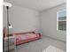Cozy bedroom featuring a pink-themed bed, neutral-colored carpet, and a window bringing in natural light at 1998 Sarah St, Winter Haven, FL 33884