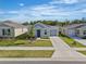 Charming single Gathering home with a well manicured lawn and driveway with beautiful blue sky at 1998 Sarah St, Winter Haven, FL 33884