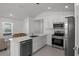 A spacious kitchen features stainless steel appliances, a long white counter, and neutral tiled flooring at 1998 Sarah St, Winter Haven, FL 33884