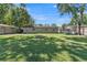 Spacious backyard featuring a fire pit, green grass, a trampoline, and a wood fence at 210 Pinehurst Dr, Auburndale, FL 33823