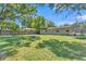 Lush backyard with ample green space, a fire pit, trampoline, and fully fenced in at 210 Pinehurst Dr, Auburndale, FL 33823