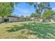 Expansive backyard with lush green grass, a fire pit, trampoline, and fenced perimeter at 210 Pinehurst Dr, Auburndale, FL 33823