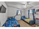 Bright bedroom with two twin beds, colorful dinosaur-themed bedding, and natural light from the window at 210 Pinehurst Dr, Auburndale, FL 33823