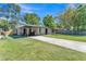 Single story home with a covered carport, a well-maintained lawn, and a long driveway at 210 Pinehurst Dr, Auburndale, FL 33823